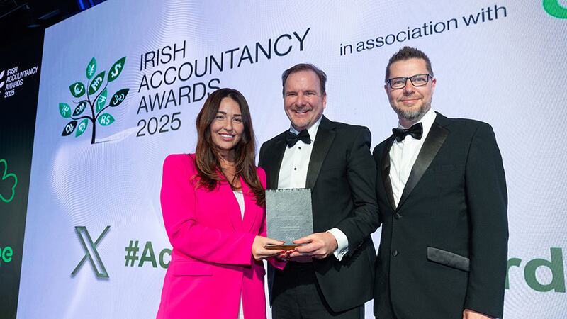 Paige Driver, transformation manager, Sage, presents the best use of technology in accounting and finance award to Karl Nolan and Mark Cliffe, Taxback International